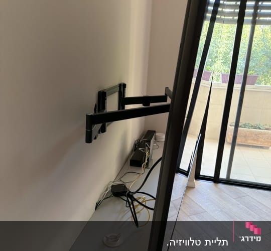 התקנת טלוויזיה על זרוע מתכווננת ליד חלון